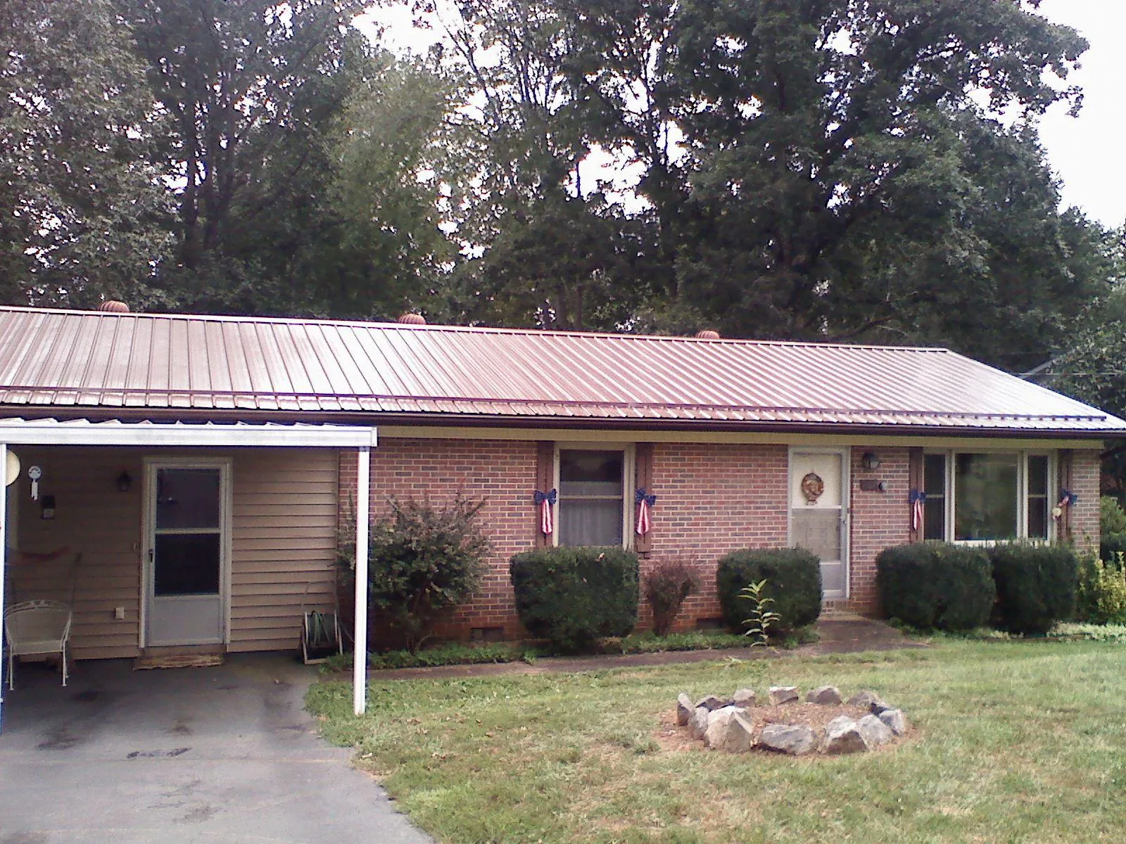 Bronze metal roof and carport on a brick ranch home — Roof Repair work by our crew in Denton